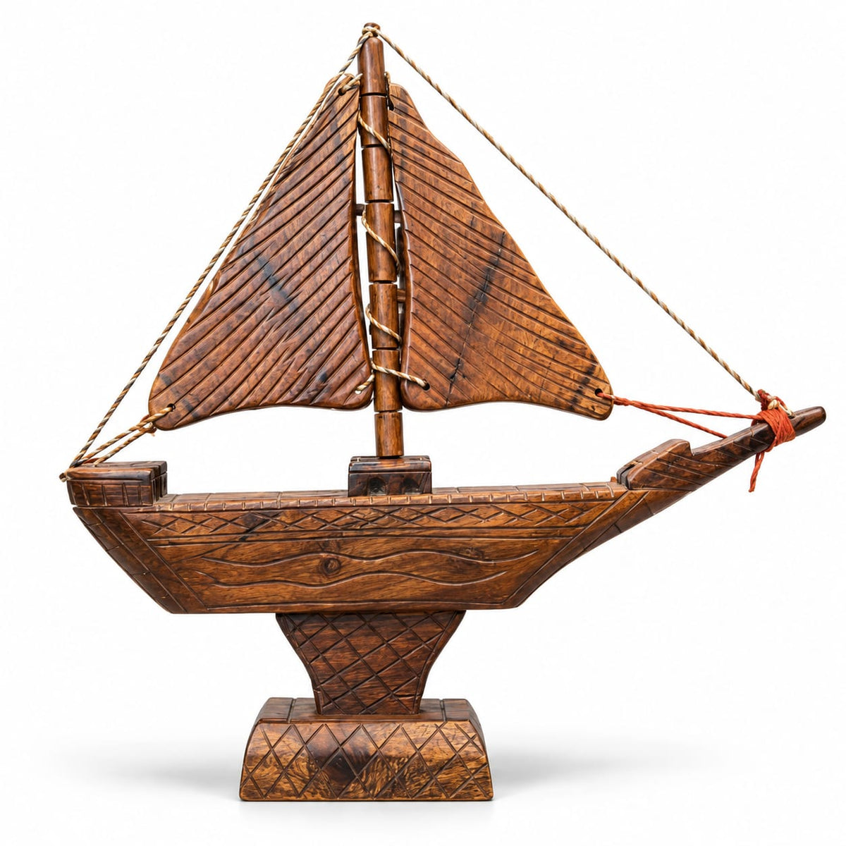 Handcrafted wooden sailboat model on white background