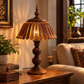 Carved wooden table lamp glowing with warm ambient light